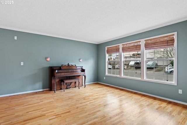 sitting room with wood finished floors, baseboards, and ornamental molding