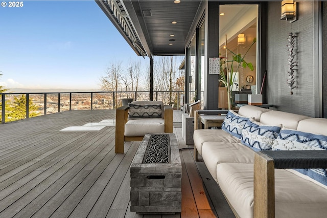 wooden deck with an outdoor living space with a fire pit