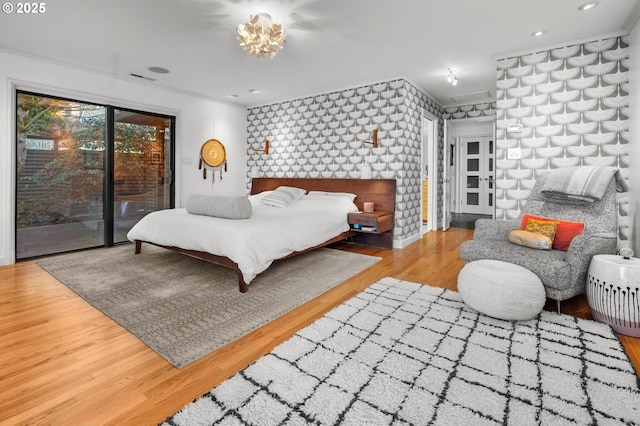 bedroom featuring light hardwood / wood-style floors, access to exterior, and crown molding