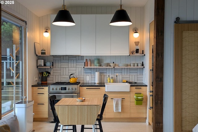 kitchen with sink, pendant lighting, gas stove, and tasteful backsplash