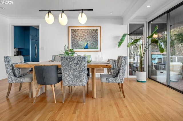 dining room with crown molding and light hardwood / wood-style flooring