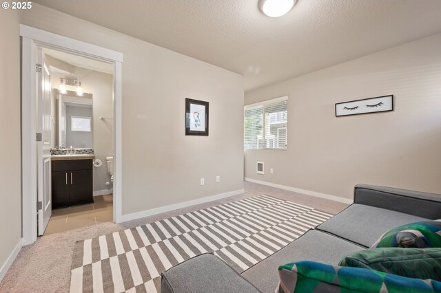 14139 SW Burlwood Ln, Beaverton, OR 97005 - bedroom with light colored carpet, a textured ceiling, and connected bathroom