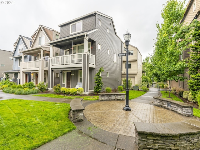 14139 SW Burlwood Ln, Beaverton, OR 97005 - view of front facade featuring a balcony, a front lawn, and board and batten siding