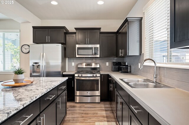 14139 SW Burlwood Ln, Beaverton, OR 97005 - kitchen with appliances with stainless steel finishes, tasteful backsplash, light wood-style floors, and recessed lighting