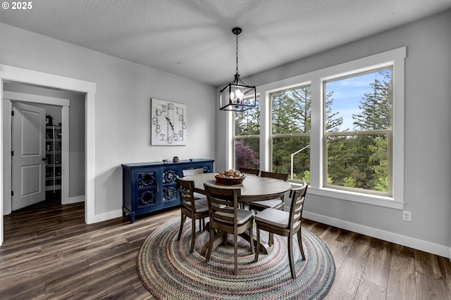 dining area featuring baseboards, a chandelier, dark wood finished floors, and a textured ceiling