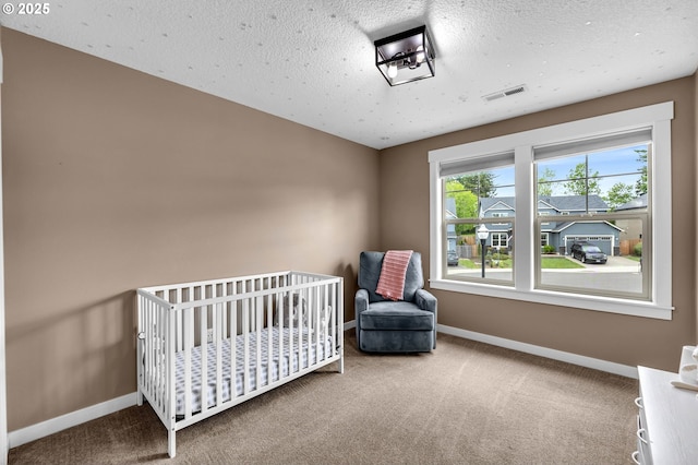 carpeted bedroom featuring baseboards and a crib