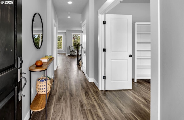 hallway featuring dark wood-style flooring, baseboards, and recessed lighting
