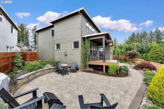 back of property featuring a patio, a deck, and fence