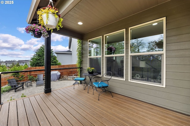 wooden terrace featuring fence and a patio