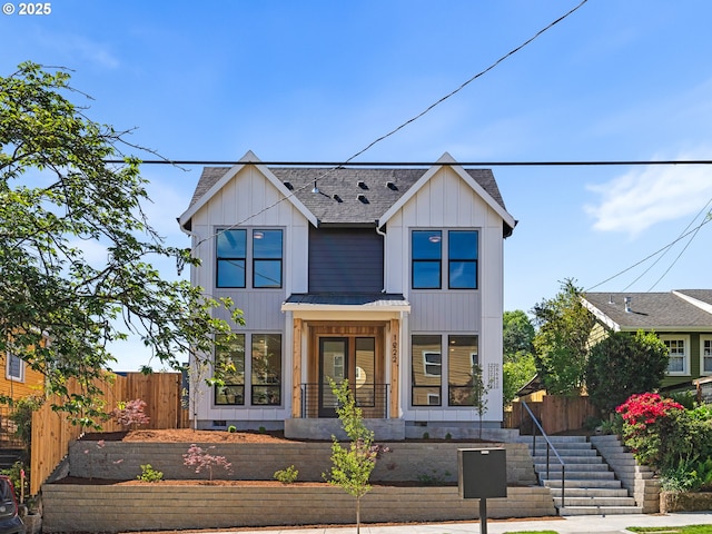 view of front of home with a shingled roof, fence, a standing seam roof, and metal roof