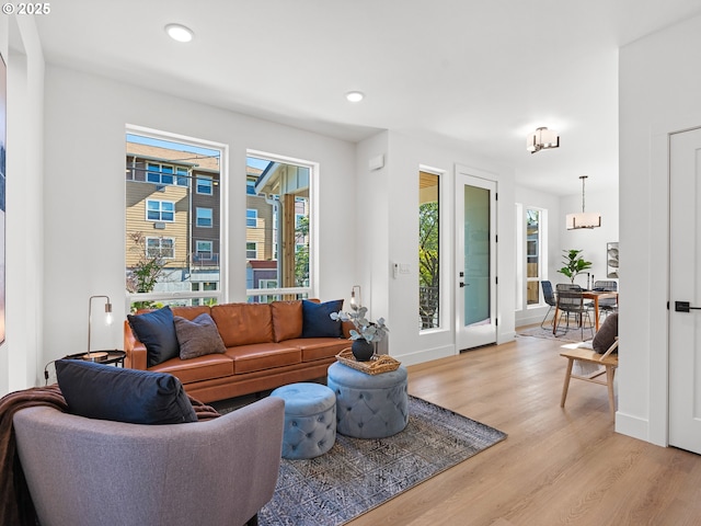 living room with light wood-style flooring, recessed lighting, baseboards, and a chandelier