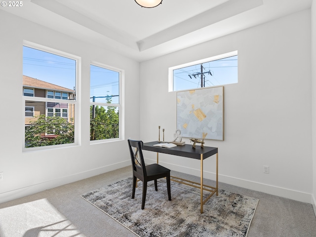 carpeted office featuring baseboards and a tray ceiling
