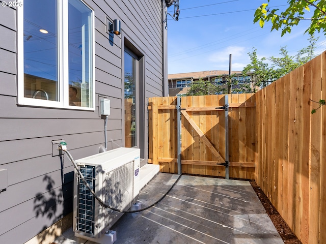 view of property exterior featuring a gate, fence, and a cooling unit