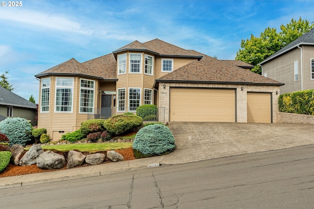 view of front of property with a garage, concrete driveway, roof with shingles, and brick siding