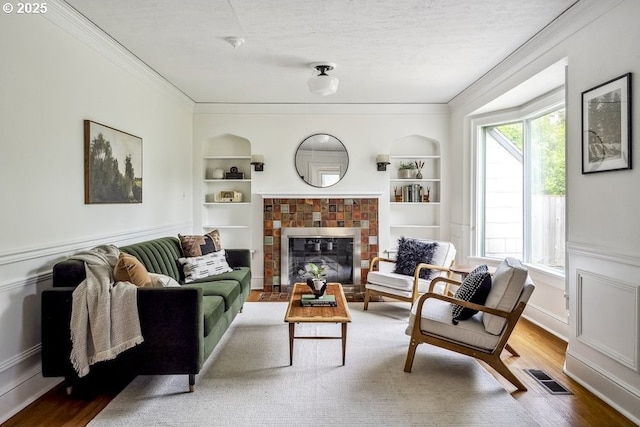 1968 SE 25th Ave, Portland, OR 97214 - living area with ornamental molding, built in features, wood finished floors, a textured ceiling, and a fireplace