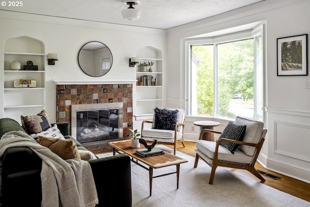 1968 SE 25th Ave, Portland, OR 97214 - living room featuring ornamental molding, wood finished floors, healthy amount of natural light, a fireplace, and built in shelves