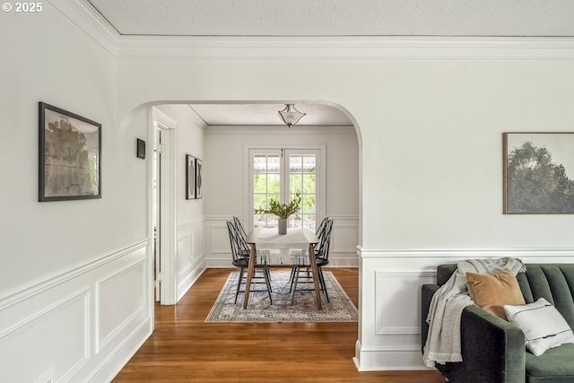 1968 SE 25th Ave, Portland, OR 97214 - dining area with arched walkways, ornamental molding, wood finished floors, a decorative wall, and wainscoting