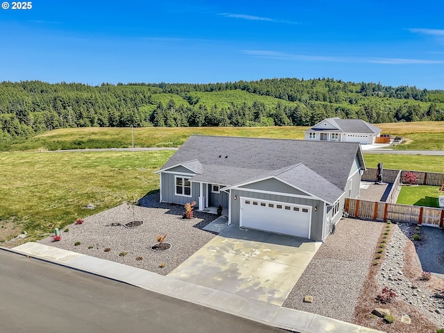 1155 SE Bugle Ave, Warrenton, OR 97146 - ranch-style house with board and batten siding, a wooded view, a garage, and concrete driveway