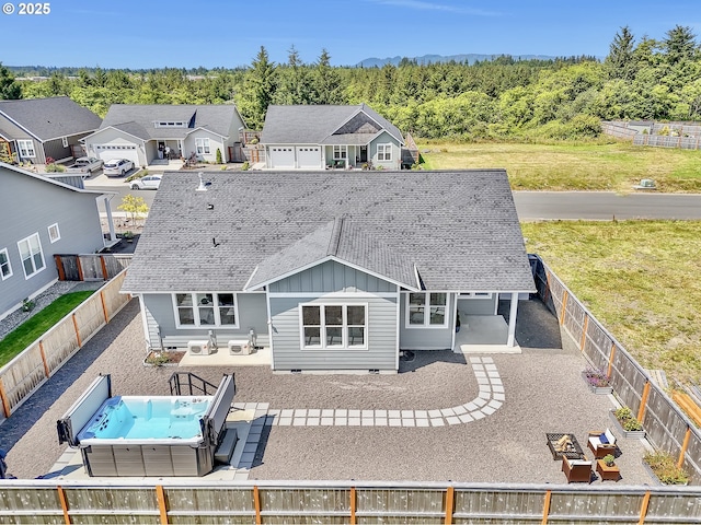 1155 SE Bugle Ave, Warrenton, OR 97146 - back of house with board and batten siding, a fenced backyard, a patio area, and a shingled roof