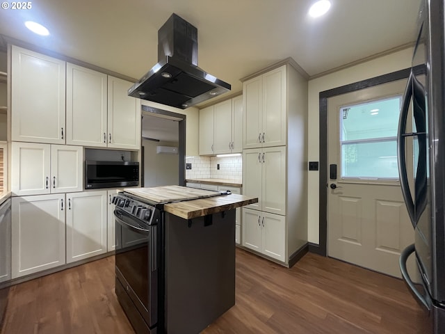 kitchen with black appliances, dark wood-style floors, butcher block counters, and island range hood