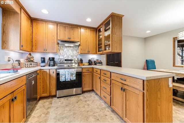 kitchen featuring under cabinet range hood, stainless steel appliances, a peninsula, brown cabinetry, and light countertops