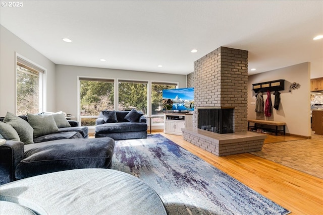 living room featuring a fireplace, recessed lighting, and wood finished floors