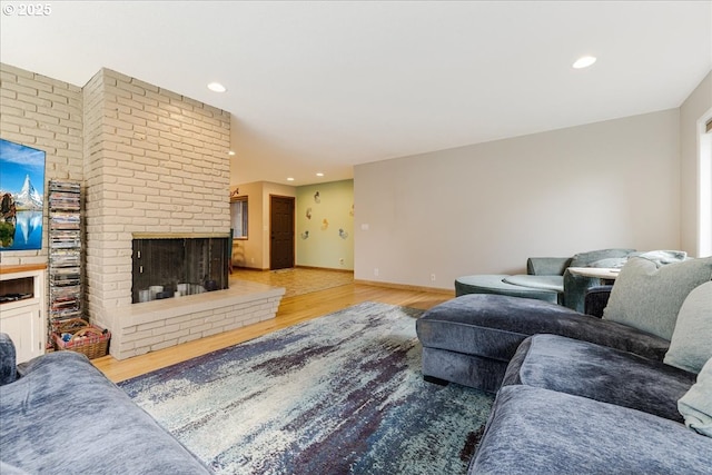 living room featuring wood finished floors, recessed lighting, a fireplace, and baseboards