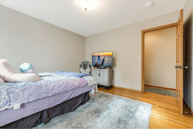 bedroom with baseboards and light wood finished floors