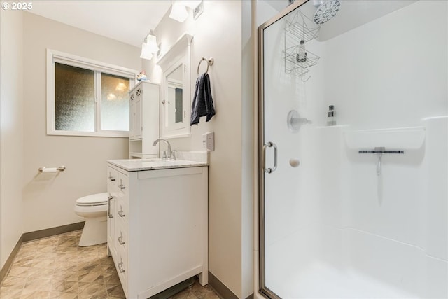 full bath featuring baseboards, vanity, a shower stall, and toilet