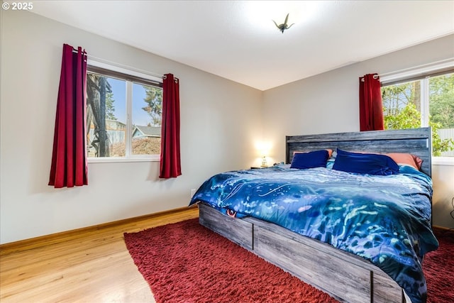 bedroom with baseboards and wood finished floors