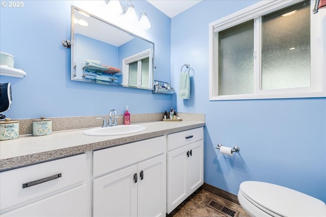 bathroom with visible vents, baseboards, toilet, and vanity