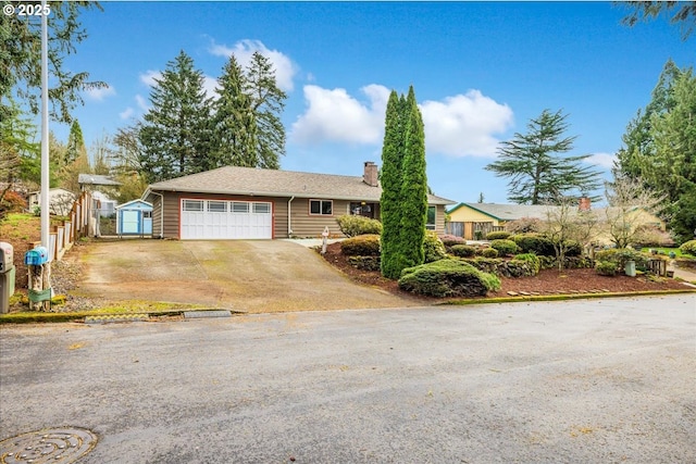 ranch-style home featuring concrete driveway, an attached garage, and a chimney