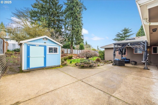 view of patio featuring an outbuilding, a shed, an outdoor hangout area, and fence