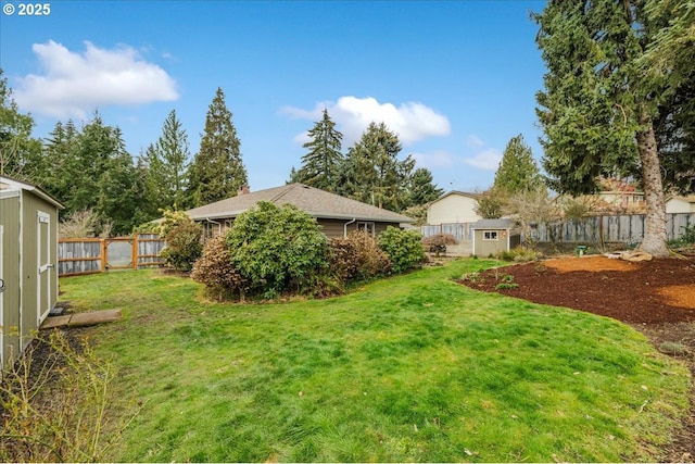 view of yard featuring a storage unit, an outdoor structure, and a fenced backyard