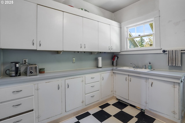 2869 SE Sherman St, Portland, OR 97214 - kitchen featuring light countertops, light floors, and white cabinets