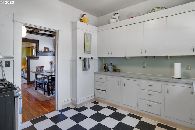 2869 SE Sherman St, Portland, OR 97214 - kitchen with stainless steel range with gas cooktop, light floors, light countertops, and white cabinetry
