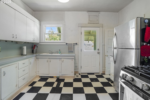 2869 SE Sherman St, Portland, OR 97214 - kitchen with light flooring, light countertops, white cabinetry, and stainless steel appliances