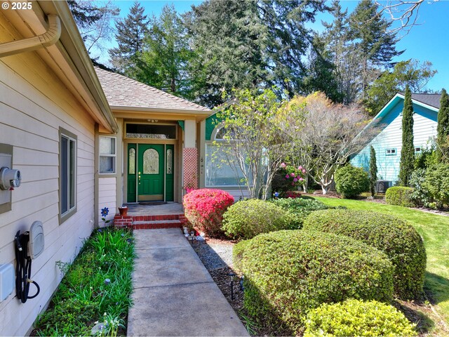entrance to property featuring roof with shingles