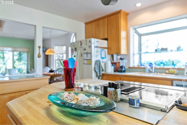 kitchen featuring a sink, light countertops, freestanding refrigerator, and recessed lighting