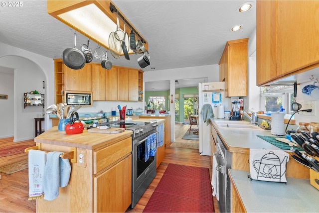 kitchen featuring light wood-style flooring, open shelves, recessed lighting, a sink, and stainless steel appliances
