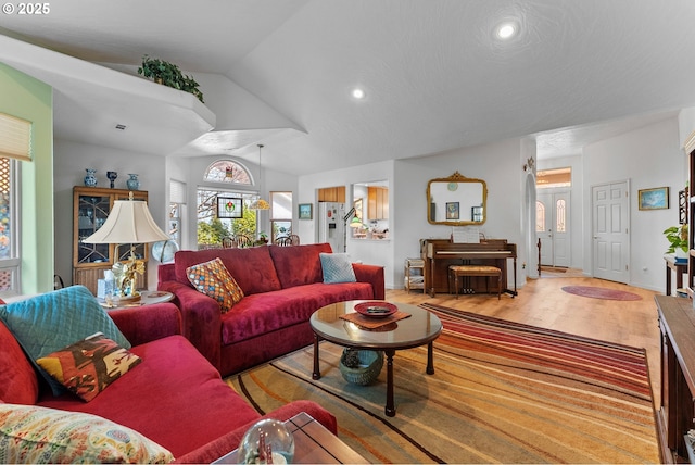 living area with recessed lighting, light wood-style floors, and vaulted ceiling