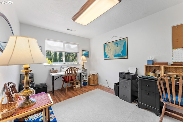 office featuring wood finished floors, baseboards, and visible vents