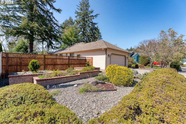 view of side of property featuring an outbuilding, driveway, fence, and a garage