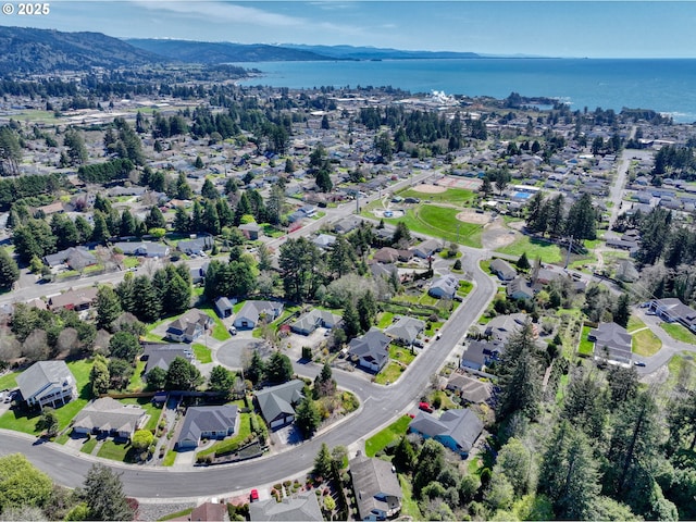 drone / aerial view featuring a water and mountain view and a residential view