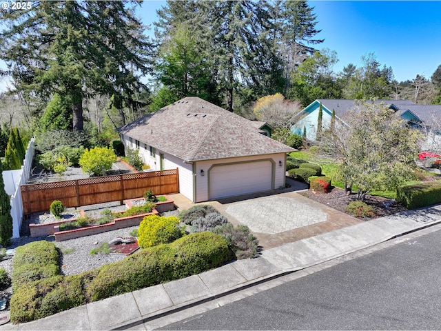 single story home featuring a garden, driveway, a garage, and fence
