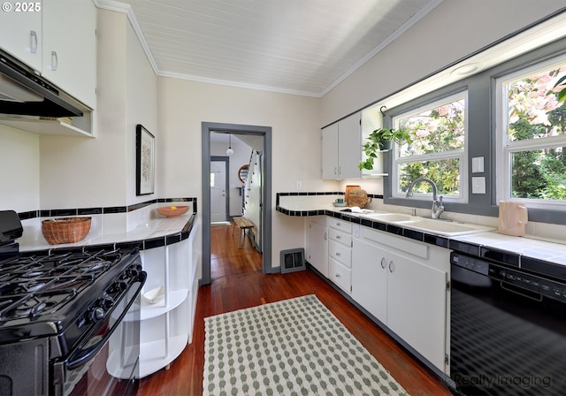 kitchen with black appliances, tile countertops, a sink, white cabinets, and ornamental molding