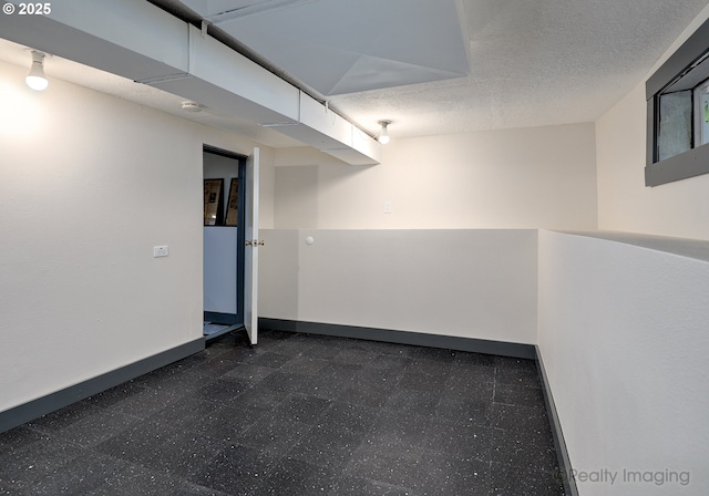 finished basement with baseboards and dark flooring