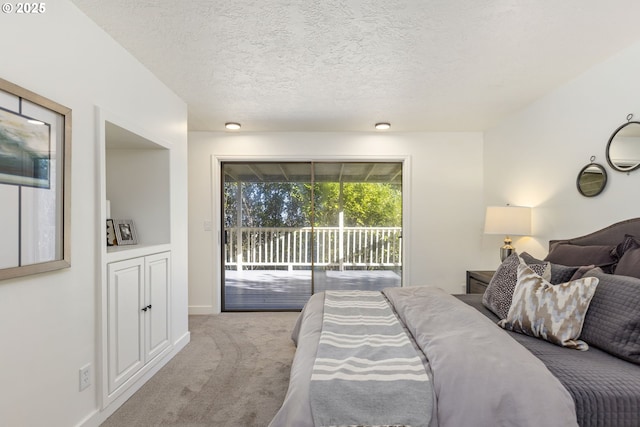 carpeted bedroom featuring access to outside and a textured ceiling