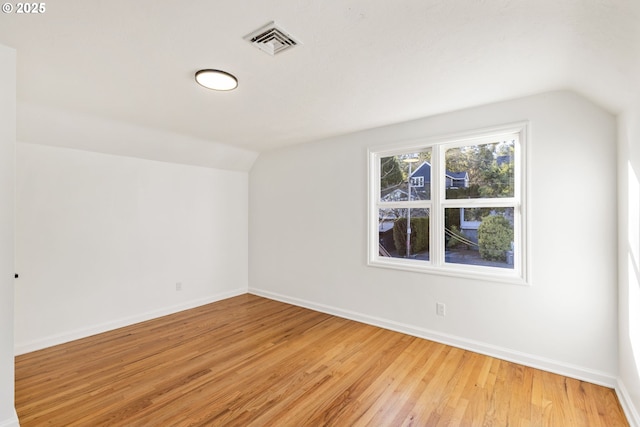 bonus room with lofted ceiling and light hardwood / wood-style floors