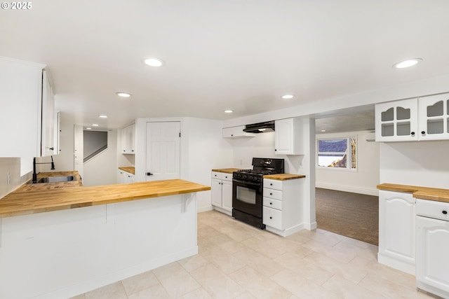 kitchen with butcher block countertops, sink, white cabinetry, gas stove, and kitchen peninsula